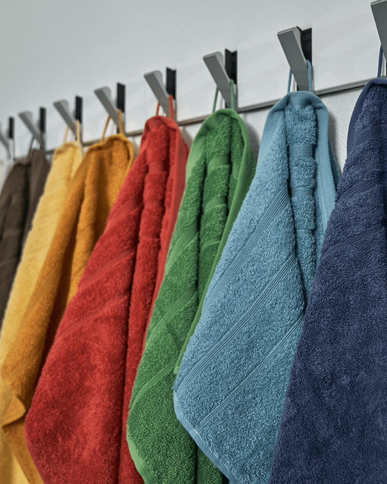 Farverige håndklæder hængende på en knage