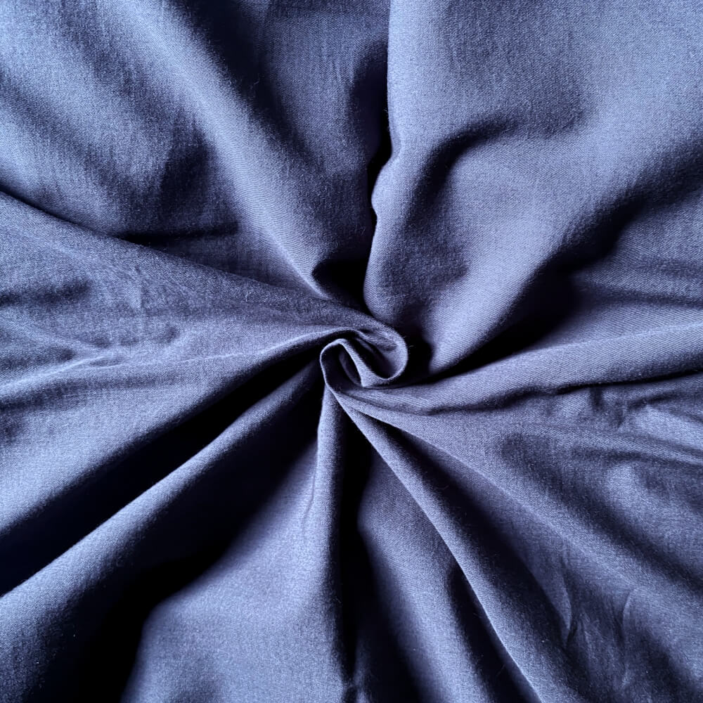 Mørkeblåt bomuldssengetøj med en krøl på midten 