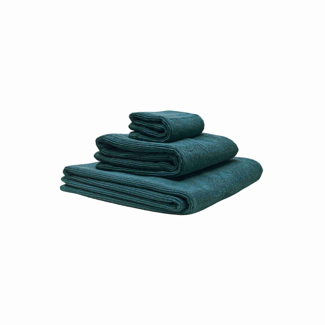 Håndklæder i økologisk bomuld og af forskellig størrelser stablet oven på hinanden. Farven på håndklæderne er petroliumsblå.