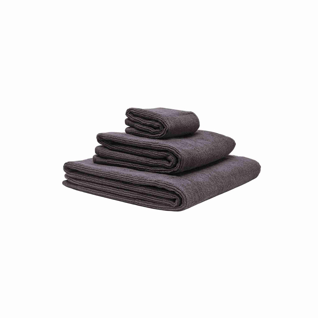 Tre håndklæder i økologisk bomuld og af forskellig størrelser stablet oven på hinanden. Farven på håndklæderne er stålgrå.