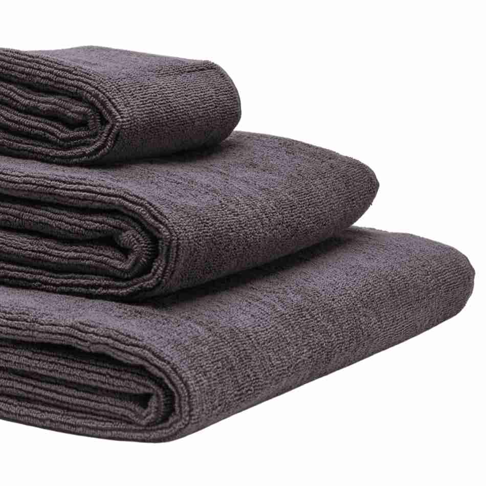 Tre økologiske håndklæder i farven grå ses tæt på.